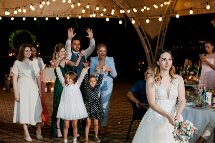 bride in a white dress throws a wedding bouquet