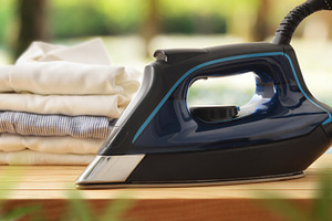 Eco-friendly ironing concept with iron on wooden in nature, a Technology Photo by Davizro's Market