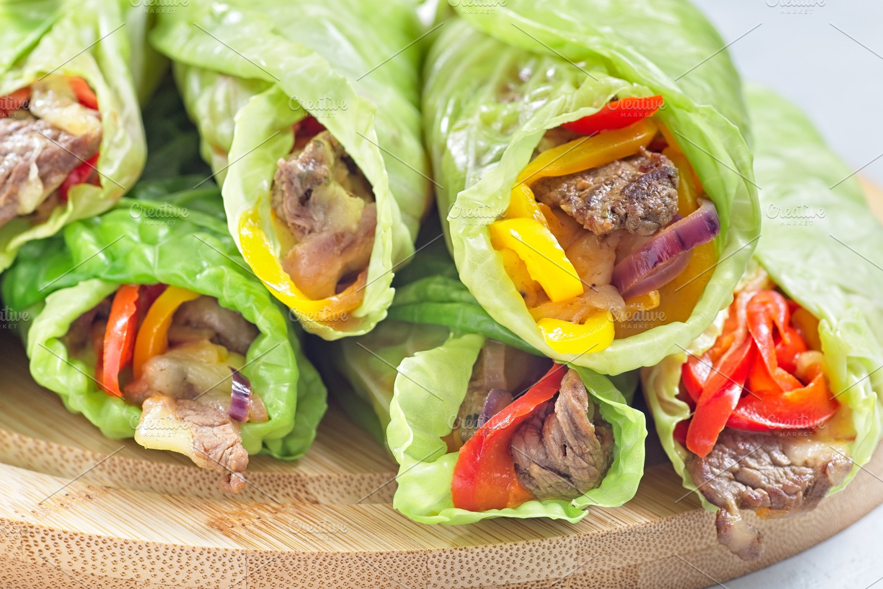 Cabbage leaves wraps with beef, vegetables and cheese, on a round wooden board,, a Food & Drink Photo by iuliia_n