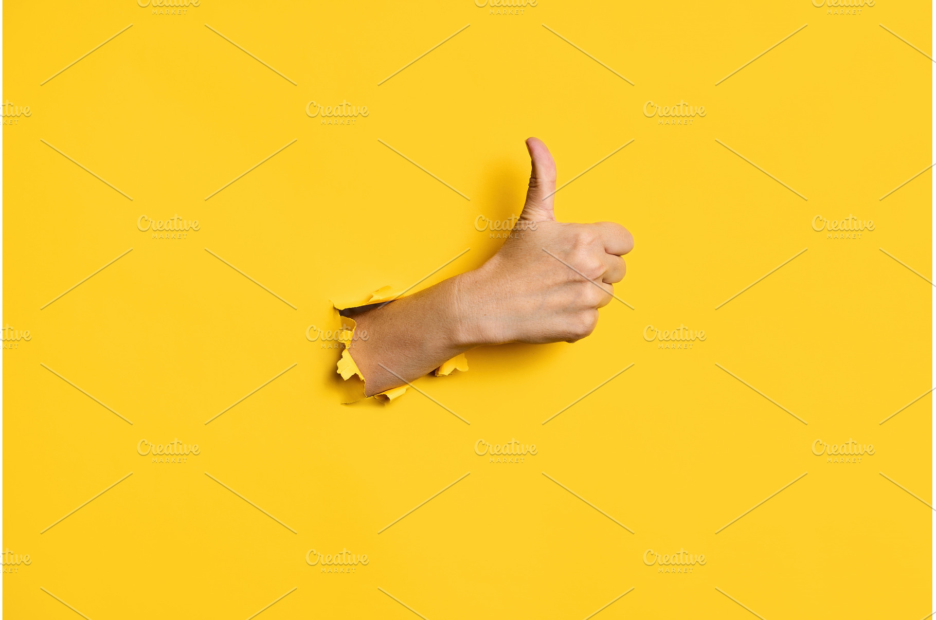 Thumb up hand gesture through hole, a Business Photo by Gladkov photography