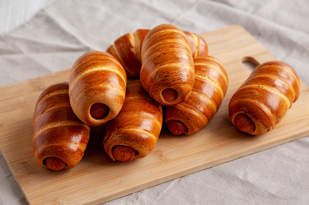 Homemade Sausage Buns on a bamboo board, side view., a Food & Drink Photo by LiudmylaChuhunova