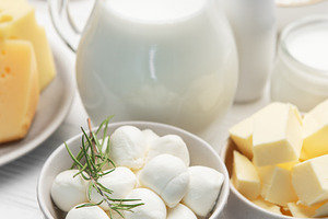 Assortment of fresh dairy products on white table, a Food & Drink Photo by Olena Rudo