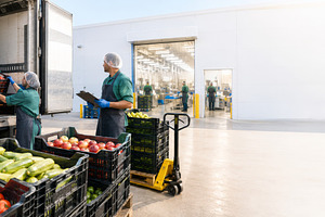 Workers unloading fresh produce at d, a Photo by Dvoevnore photos