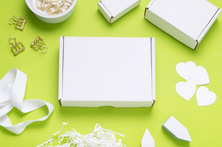 White Cardboard box on color office desk, a Background Photo by MDBildes