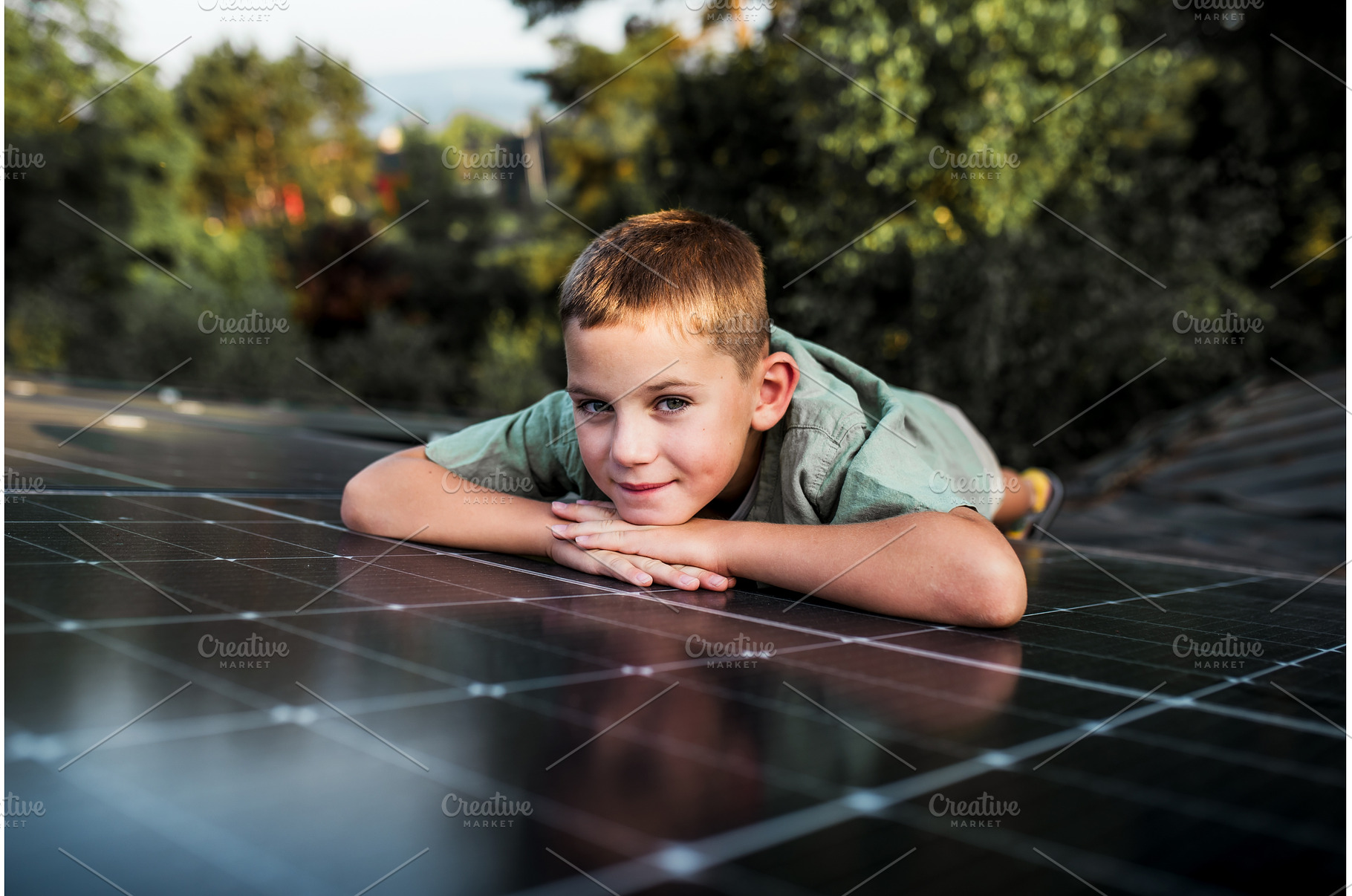 Boy lying on roof with solar panels, a Technology Photo by HalfPoint