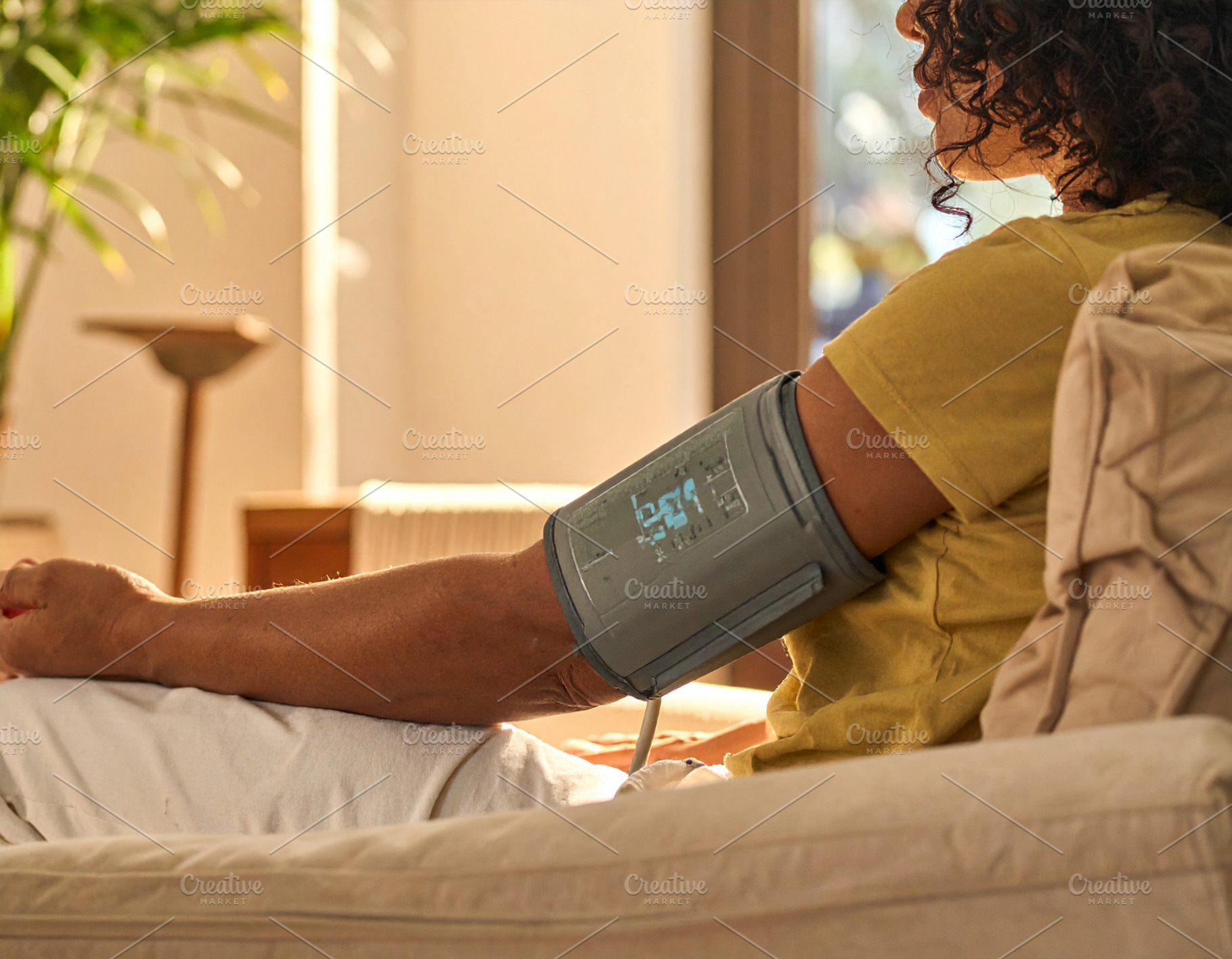 Blood pressure monitor placed on the arm of a person sitting in, a Person Photo by DanFLCreativo