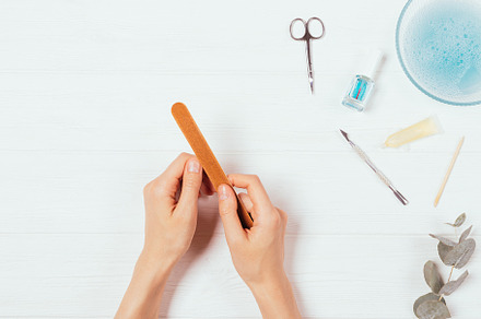 Female hands treat nails with file n, a Beauty & Fashion Photo by progressman