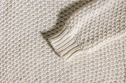 Wool sweater sleeve on texture background