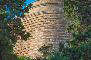 Ancient Maiden Tower in Baku through green trees with copy space, a Photo by Pictures for you!!!!!!!!!