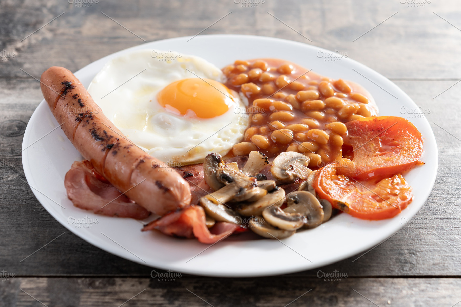 Full English breakfast with fried egg, bacon, sausages and beans, a Food & Drink Photo by etorres69