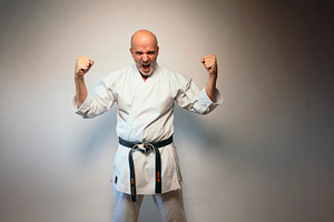 Martial artist shouting with raised clenched fists., a Person Photo by karrastock
