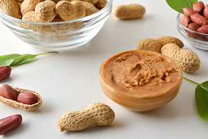 Bowl full of peanut butter on white table with fruits, a Food & Drink Photo by Davizro's Market