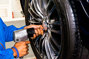 Mechanic screwing wheel stock photo containing car and tire