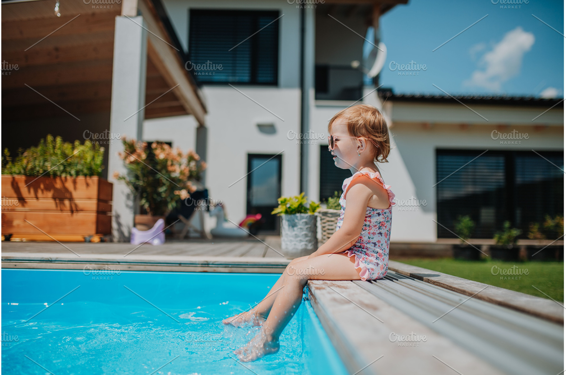 Little girl sitting by pool, a Person Photo by HalfPoint