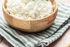 Cottage cheese in wooden bowl with mint leaf, a Food & Drink Photo by Olena Rudo