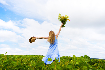 Beautiful happy girl in a hat with a bouquet of flowers, chic green field, a Nature Photo by Artsaba Family
