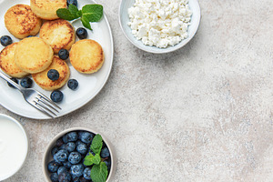 Syrniki cottage cheese pancakes served with fresh blueberries an, a Food & Drink Photo by Olena Rudo