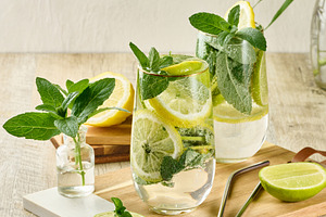 Refreshing citrus and mint drink in glasses with ice, lemon, lim, a Food & Drink Photo by ndanko