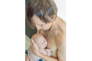 Father cuddling his sleeping newborn, a Person Photo by Elizaveta Galitskaya