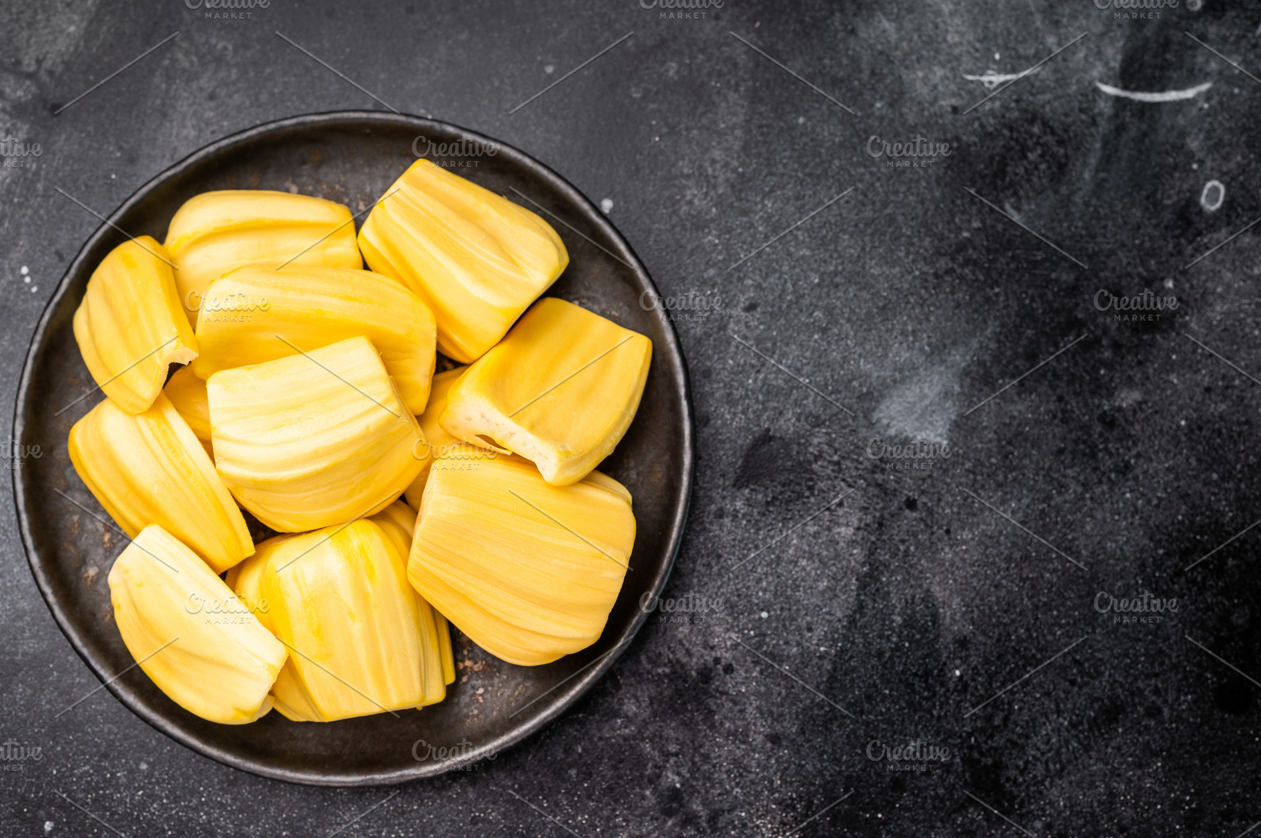 Sweet, golden yellow jackfruit pods (bulbs) served in a black pl, a Photo by composter-box@mail.ru