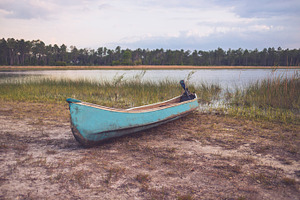 Small Motorized Canoe on Lake Shore