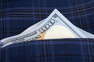 A crisp one hundred dollar bill partially visible in the pocket of a blue plaid, a Business Photo by Ales Munt