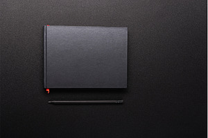 Minimalist black notebook with a red, a Background Photo by Stockphoto by vzwer