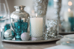 Elegant silver and turquoise table centerpiece with lit candle,, a Photo by Studio ANNA