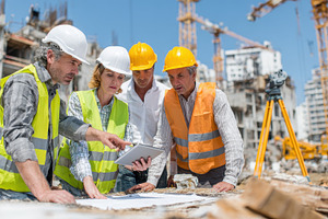 Construction team reviewing plans on, a Photo by Pixeness Studio