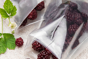 Frozen blackberries spilling from vacuum seal bags, a Food & Drink Photo by Olena Rudo