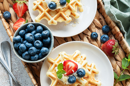 Freshly baked waffles with strawberries and blueberries, a Food & Drink Photo by Olena Rudo