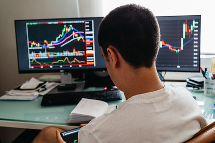 Successful young trader in casual wear working with charts and market reports a, a Person Photo by Architect´s eye