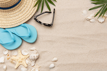 Beach accessories lying on sand creating summer vacation backgro