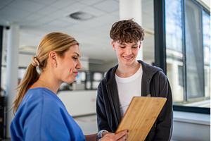 Doctor talking with teenage boy in, a Person Photo by HalfPoint