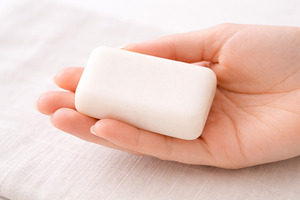 Soap bar held in hand on fabric back, a Photo by Dvoevnore photos