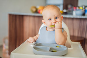 Baby enjoying green vegetables, a Person Photo by Elizaveta Galitskaya