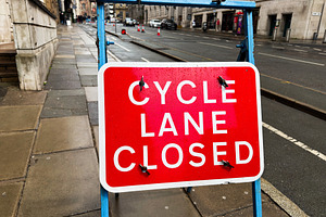 Cycle lane closed sign on wet street in Liverpool UK with blue f