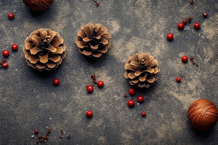 New Year's and Christmas background featuring brown pinecones and red baubles,, a Holiday Photo by ImageMir