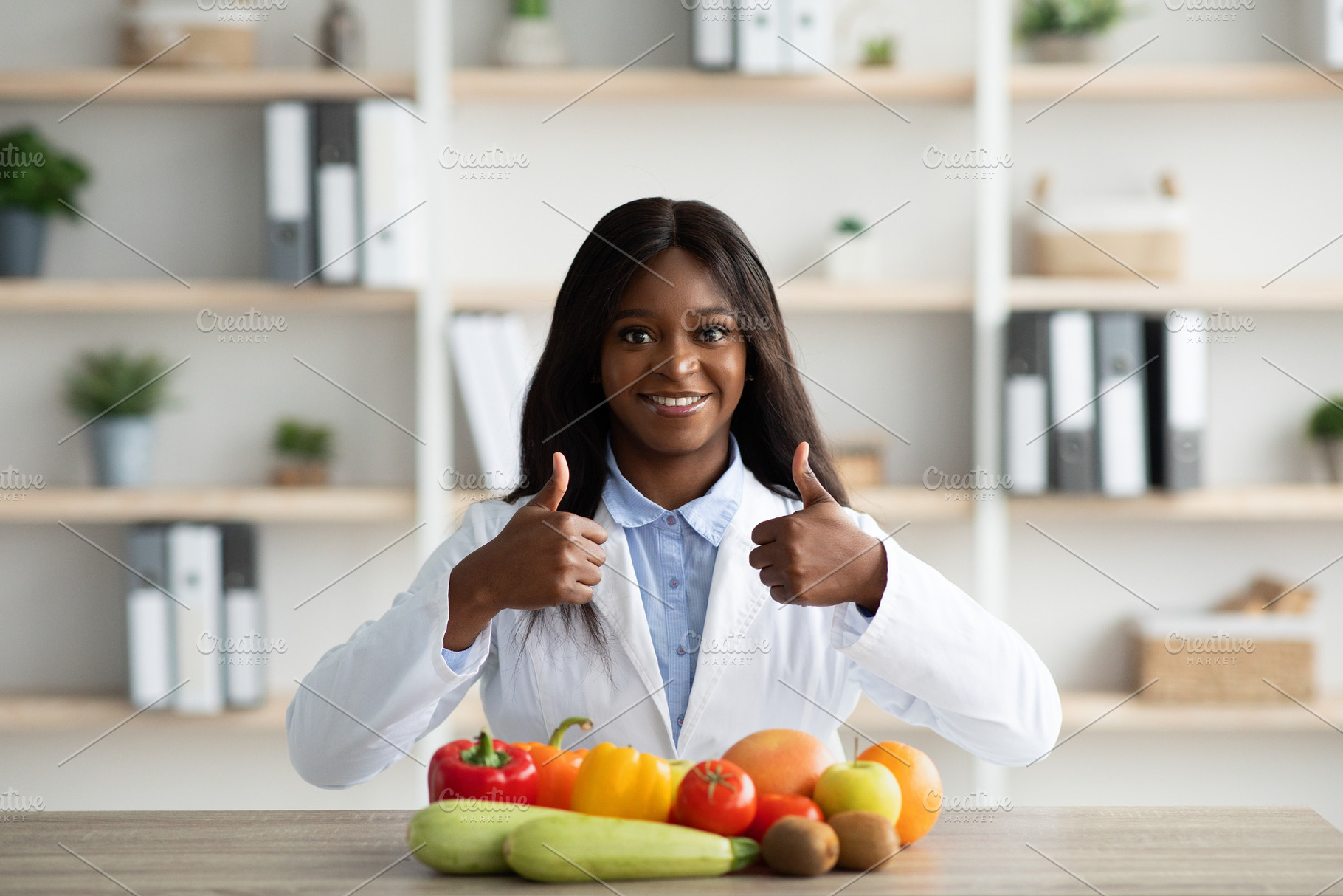Young african american female nutritionist recommending eating fruits and veget, a Person Photo by Prostock-Studio