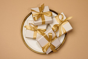 Gift boxes with gold bows on a white plate with a gold rim. A fe, a Food & Drink Photo by ndanko