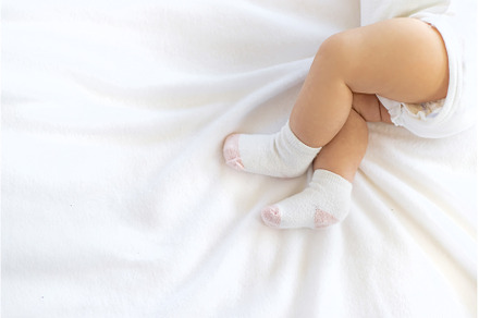 Baby feet in socks against white, a Person Photo by yanadjana