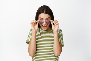 Excited girl taking off sunglasses