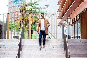 Man walking down stairs in modern city architecture, a Person Photo by RF Images
