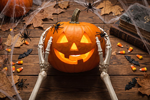 skeleton holding Halloween pumpkin