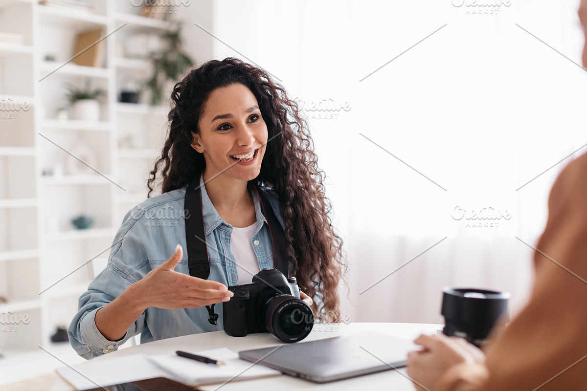 Positive Photographer Woman Talking To Lady Sitting In Modern Office, a Photo by Prostock-Studio (Photo 2 of 4)