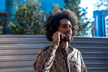 Young afro man using cellphone outdoor, a Person Photo by 2Design