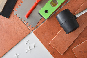 Laying tiles with spacers with tools on top, an Architecture Photo by Davizro's Market
