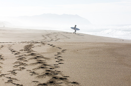 Surfer in the distance featuring beach, surf, and surfer