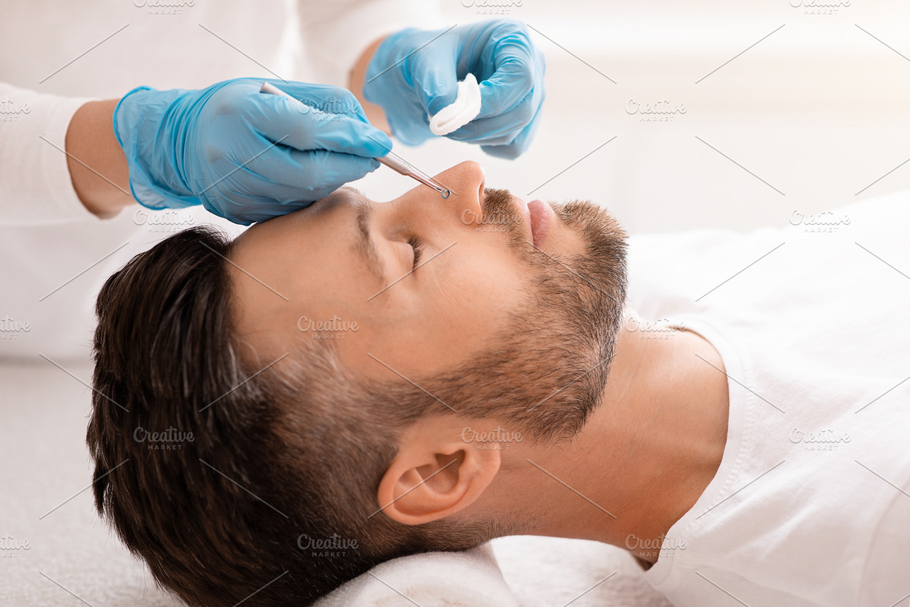 Man resting with closed eyes while beautician removing black heads, a Photo by Prostock-Studio