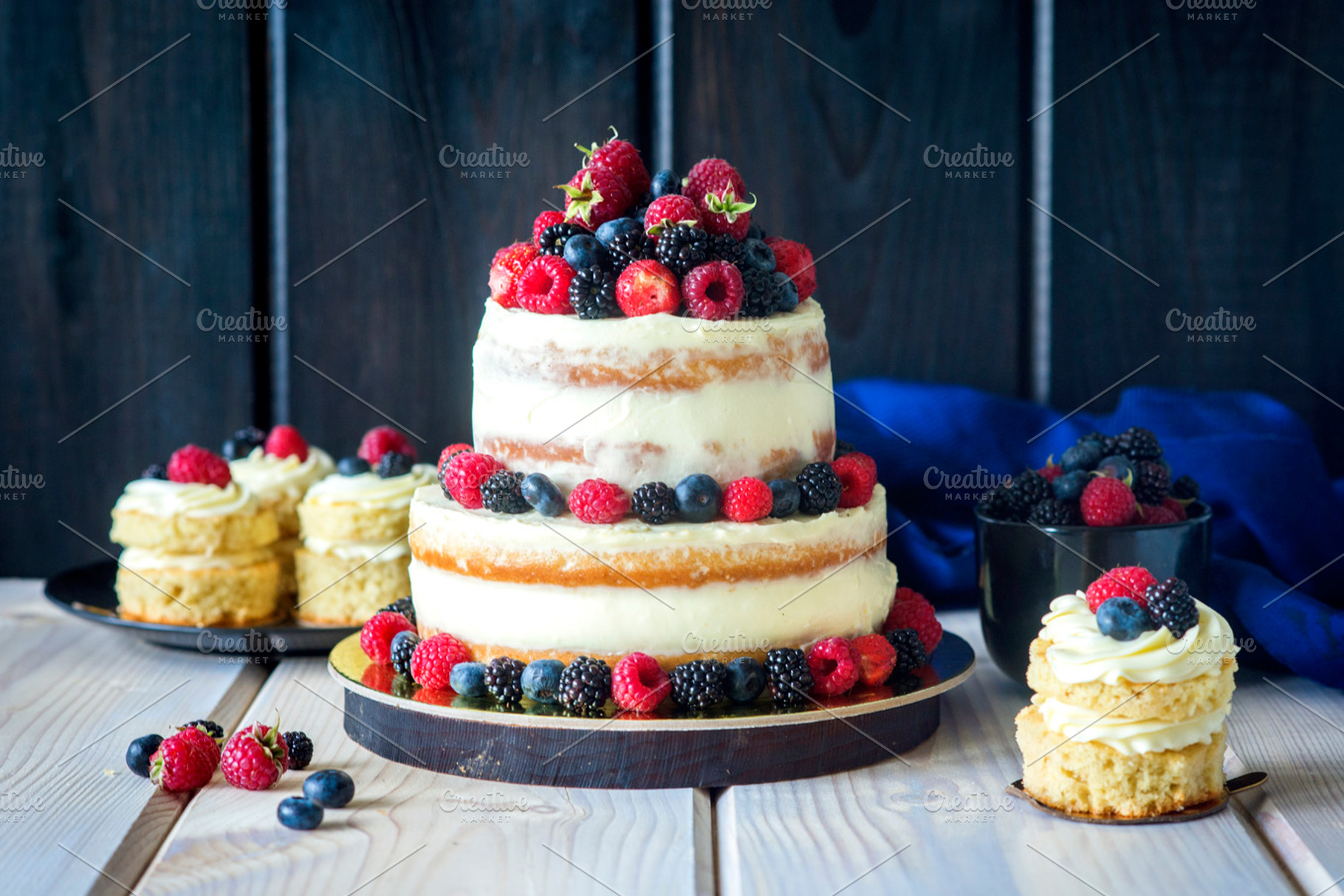 Two tiered white semi naked cake with fresh berries for a wedding or a party, a Food & Drink Photo by saharisha